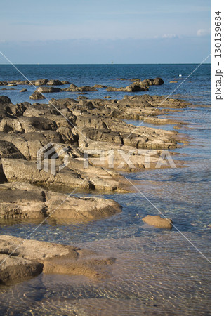 Ancient limestone formations creating natural terraces along pristine Mediterranean coastline with crystal clear waters Ancient limestone formations creating natural terraces along pristine Mediterranean coastline with crystal clear waters 130139684