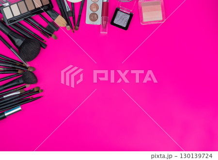 Professional beauty flatlay featuring makeup brushes, eyeshadow palettes, and cosmetics arranged on bright pink background with copy space Professional beauty flatlay featuring makeup brushes, eyeshadow palettes, and cosmetics arranged on bright pink background with copy space 130139724