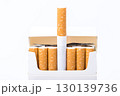 Open cigarette pack revealing orange filter tobacco products against clean white background for health awareness campaigns 130139736