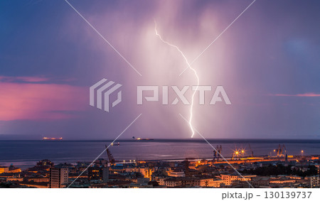 Massive cloud to ground lightning bolts hitting the horizon of city lights Massive cloud to ground lightning bolts hitting the horizon of city lights 130139737