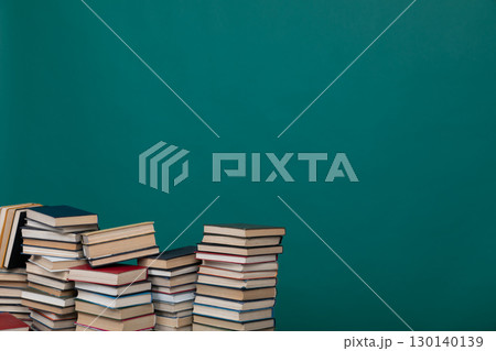 Stacks of educational books for teaching in the school library on a green background 130140139