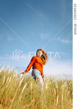 Beauty woman enjoying nature outdoors in grass. Calmness and tranquility. Travel, tourism concept. Beauty woman enjoying nature outdoors in grass. Calmness and tranquility. Travel, tourism concept. 130140510