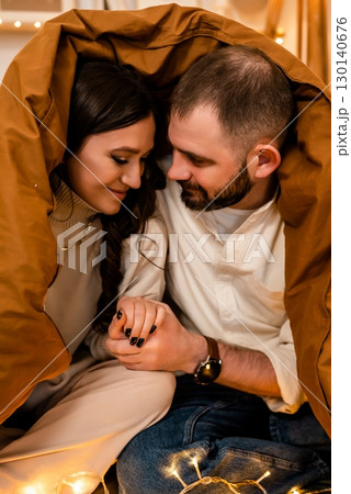 Cozy Couple Holding Hands Under Blanket Cozy Couple Holding Hands Under Blanket 130140676