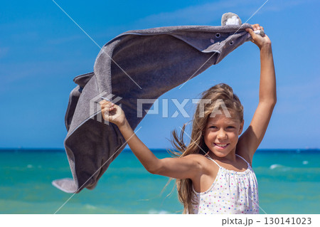 Young kid bouncing a blanket at the seaside Young kid bouncing a blanket at the seaside 130141023
