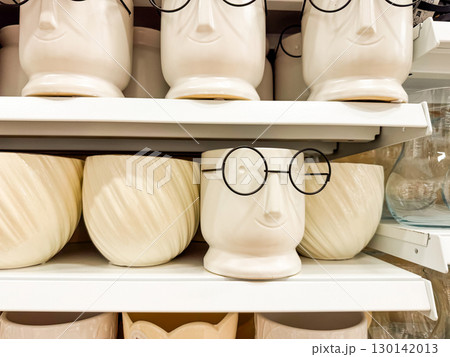 White ceramic pots with face design and glasses. Humor, creativity, and modern decoration for stylish interiors. White ceramic pots with face design and glasses. Humor, creativity, and modern decoration for stylish interiors. 130142013