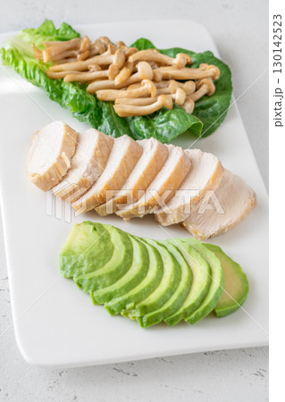 Avocado, mushrooms, and chicken presented as fresh minimalist healthy lifestyle plate 130142523