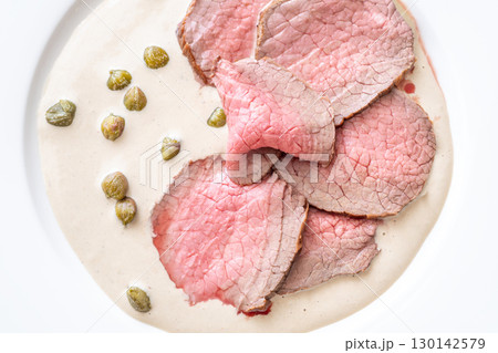 Elegant Vitello Tonnato with scattered capers and creamy sauce on plate Elegant Vitello Tonnato with scattered capers and creamy sauce on plate 130142579