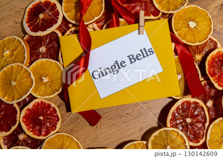 Greeting card with GINGLE BELLS text on handmade Christmas wreath. Festive mood new year celebration. Postcard decoration decor Greeting card with GINGLE BELLS text on handmade Christmas wreath. Festive mood new year celebration. Postcard decoration decor 130142609