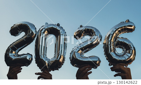 Silver foil number 2026 celebration new year balloon on blue sky background. Happy New year greetings concept. Hands holding balloons two thousand twenty-fourth year Christmas holiday Silver foil number 2026 celebration new year balloon on blue sky background. Happy New year greetings concept. Hands holding balloons two thousand twenty-fourth year Christmas holiday 130142622