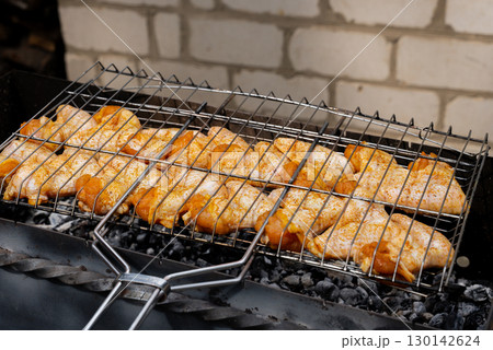 BBQ picnic time Roasted chicken legs and wings on grill. Grilling meat on outdoor grill grid tasty barbeque chicken steak with smoke flames juicy meat in the backyard BBQ picnic time Roasted chicken legs and wings on grill. Grilling meat on outdoor grill grid tasty barbeque chicken steak with smoke flames juicy meat in the backyard 130142624