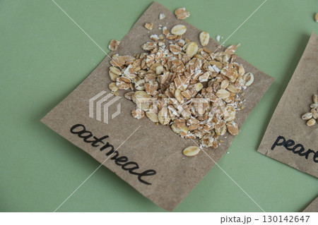 Raw oatmeal porridge with text in paper. Refill product format eco-friendly living. Filling reusable container Whole spelt grain species. High protein fiber-rich vegan plant based food ingredient Raw oatmeal porridge with text in paper. Refill product format eco-friendly living. Filling reusable container Whole spelt grain species. High protein fiber-rich vegan plant based food ingredient 130142647