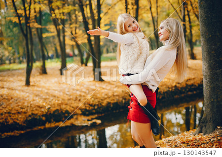 Fashionable mother with daughter. Family in a autumn park. Fashionable mother with daughter. Family in a autumn park. 130143547