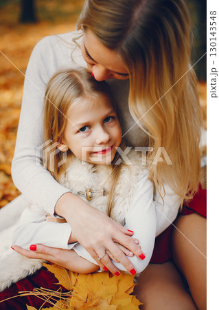 Fashionable mother with daughter. Family in a autumn park. Fashionable mother with daughter. Family in a autumn park. 130143548