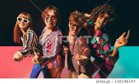 Retro disco friends laughing together in vibrant vintage costumes Retro disco friends laughing together in vibrant vintage costumes 130146147