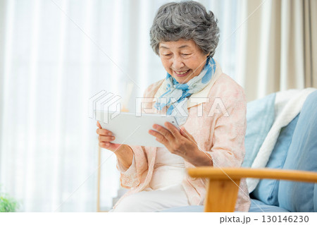 タブレット端末を使うシニア女性 130146230