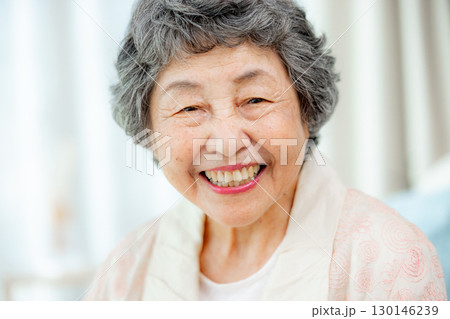 リビングで口紅を塗ってもらうシニア女性 130146239