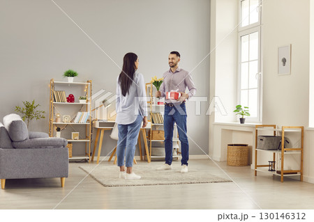 Husband Giving Wife Flowers And Gift On Valentine Day Husband Giving Wife Flowers And Gift On Valentine Day 130146312