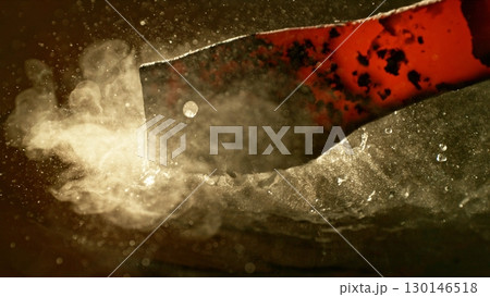 Close-up of glowing hot iron being quenched in cold water. Concept of metal forging and cooling. Close-up of glowing hot iron being quenched in cold water. Concept of metal forging and cooling. 130146518