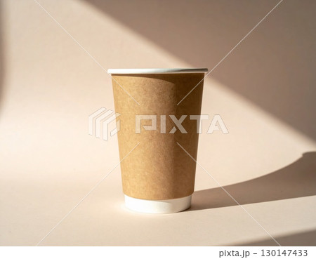 Beige Paper Coffee Cup with Cardboard Sleeve on Beige Background in Bright Sunlight Beige Paper Coffee Cup with Cardboard Sleeve on Beige Background in Bright Sunlight 130147433