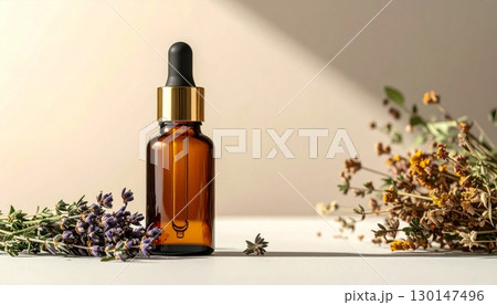 Amber Glass Dropper Bottle with Assorted Dried Herbs on White Table Against Beige Backdrop 130147496