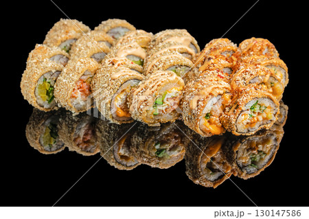 Crispy deep fried sushi rolls with sauce on black background 130147586