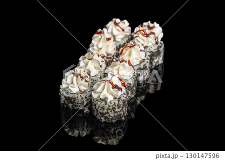 Sushi rolls topped with cream cheese and sauce on black background 130147596