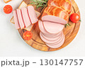 Sliced smoked sausage with bread and cherry tomatoes on wooden board. top view. copy space 130147757