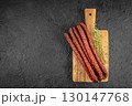 Dry cured sausages with herbs on wooden cutting board. top view. copy space 130147768