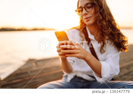 Phone in woman's hands. Communication with friends. Travel, tourism, technology, blogging concept. 130147779