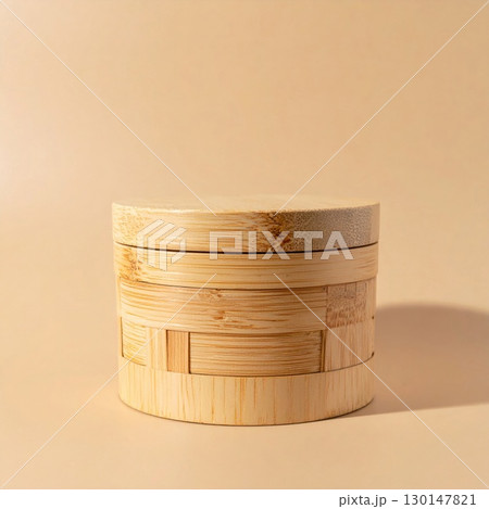 Close up Cylindrical Woven Bamboo Container On Beige Surface With Soft Lighting 130147821
