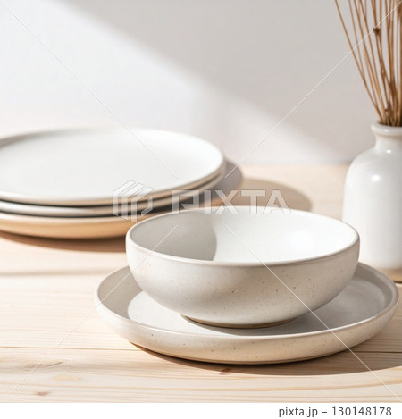 Still Life of Ceramic Tableware with Plates Bowl and Vase on Wooden Table 130148178