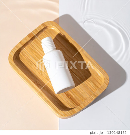 Top View of a White Cosmetic Bottle on a Wooden Tray with Water and Two Toned Background 130148183
