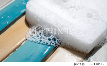 Close Up of White Foam Sponge on Colorful Rectangular Tiles With Bubble Texture in Bright Sunlight 130148517