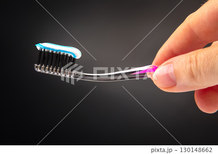 toothbrush with toothpaste for cleaning teeth on a dark background. health care toothbrush with toothpaste for cleaning teeth on a dark background. health care 130148662