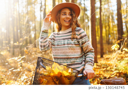 Happy active young woman on bike in autumn park at sunset. Concept of people, recreation, active lifestyle. Happy active young woman on bike in autumn park at sunset. Concept of people, recreation, active lifestyle. 130148745