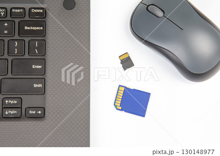 sd memory card for recording electronic data near a laptop on a white background sd memory card for recording electronic data near a laptop on a white background 130148977