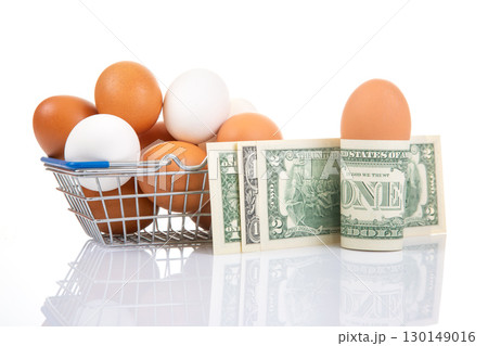 A metal shopping basket with eggs, paired with rolled dollar bills and an egg 130149016