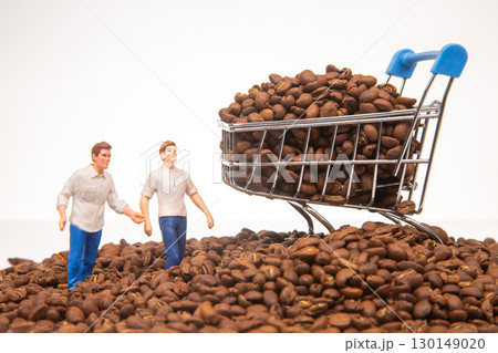 A creative stock photo featuring miniature figures on coffee beans with a shopping cart  130149020