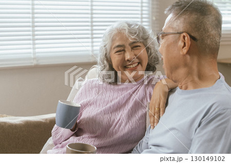 Happy couple spending time on home sofa Happy couple spending time on home sofa 130149102