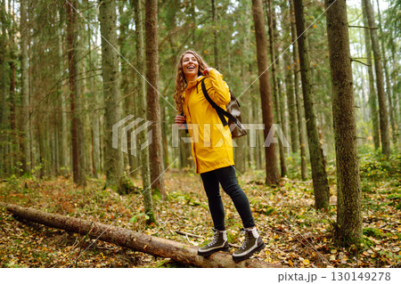Female tourist with backpack in forest walks, enjoys nature of forest. Concept of nature, relaxation Female tourist with backpack in forest walks, enjoys nature of forest. Concept of nature, relaxation 130149278
