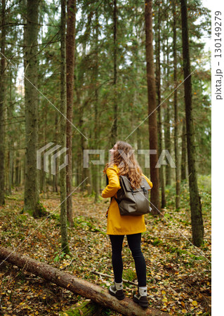 Female tourist with backpack in forest walks, enjoys nature of forest. Concept of nature, relaxation 130149279