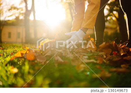 Woman cleans autumn park from yellow leaves. Volunteering, cleaning concept. Seasonal gardening. 130149673