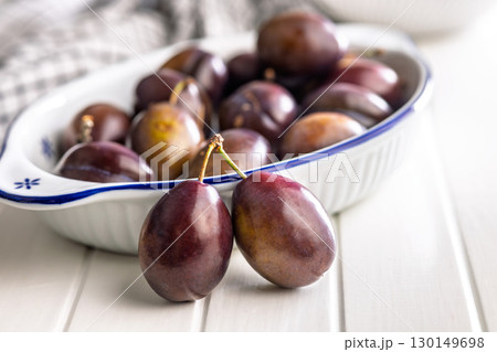 Ripe plums on white table. 130149698