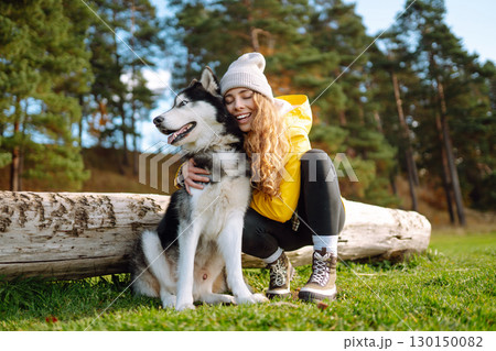 Happy female posing outdoors with her dog. Concept of friendship, vacation, walk. Happy female posing outdoors with her dog. Concept of friendship, vacation, walk. 130150082