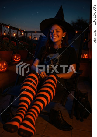 A young woman dressed as a witch on a balcony at night 130150908