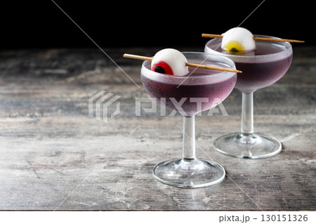 Purple Halloween cocktail garnished with candy eye Purple Halloween cocktail garnished with candy eye 130151326