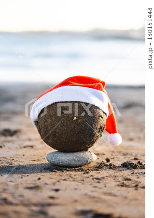 Christmas sand sculpture with Santa hat on the beach 130151448