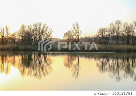 Peaceful Autumn Lake Surrounded By Vibrant Colorful Trees 130151781