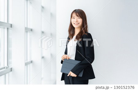 タブレットを持つ笑顔の女性・ビジネスウーマン タブレットを持つ笑顔の女性・ビジネスウーマン 130152376