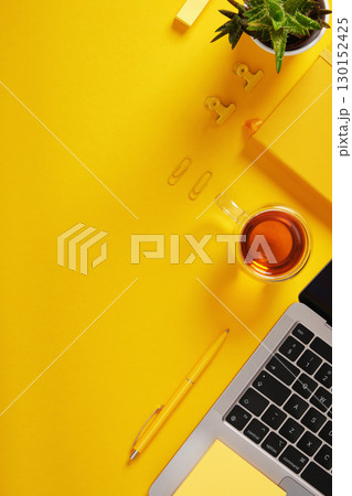 Vertical banner with office supplies and a laptop. Yellow background, space for your text. 130152425
